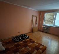 TOTO je Váš nový domov - 3 izbový byt Sereď  - Izba v 3-izbovom byte s podlahou s dreveným dekorom, jednoduché zariadenie.