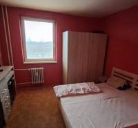 TOTO je Váš nový domov - 3 izbový byt Sereď  - Spálňa v 3-izbovom byte s posteľou, skriňou a komodou na červenej stene.