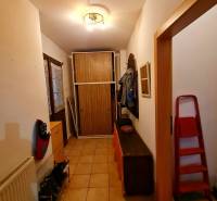 4.izb Rodinný Dom Centrum Chtelnica - Chodba v rodinnom dome s dlažbou, botníkom, vešiakom a skriňou.