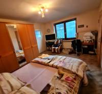 4.izb Rodinný Dom Centrum Chtelnica - Spálňa s posteľou, skriňou a stolom v rodinnom dome.