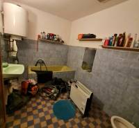 4.izb Rodinný Dom Centrum Chtelnica - Kúpeľňa v Rodinnom dome s vaňou, umývadlom, regálmi a ohrevným telesom.
