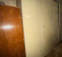 Predáme rodinný dom- Šurany, širšie centrum.  - Skriňa v rodinnom dome, pri nej je hnedý nábytok a koberec s geometrickým vzorom.