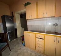 Predáme rodinný dom- Šurany, širšie centrum.  - Kuchyňa v rodinnom dome s chladničkou, skrinkami a dlaždicovou podlahou.
