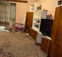 Predáme rodinný dom- Šurany, širšie centrum.  - Izba v rodinnom dome s kobercom, poličkami, televízorom a závesmi.