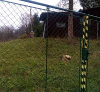 KONSKÉ - pozemok 1108 m2,okr. Martin  - Brána so zeleným pletivom, vedúca na trávnatý pozemok, blízko drevené obydlie.