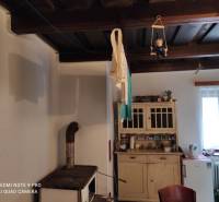 ČREMOŠNÉ-chalupa na pozemku 700m2   - Vidiecka kuchyňa s dreveným stropom a sporákom. Skrinka na druhej strane miestnosti.