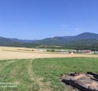 VALČA pozemok s výmerou 5800 m2,  okr. Martin  - Na obrázku je malebná krajina, lúky, polia a vzdialené hory. V pozadí vidieť domy.