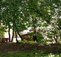 TURANY- krásna chata na pozemku 700m2 - Na obrázku sú stromy a drevená chata skrytá medzi zeleňou na ulici Černík.