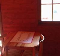 TURANY- krásna chata na pozemku 700m2 - Drevený stôl s dvoma stoličkami v útulnej chate na ulici Černík.