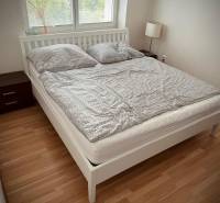 Slnečný 2i byt s balkónmi pri NC Nivy - Spálňa v 2-izbovom byte s podlahou s dreveným dekorom a dvojposteľou.