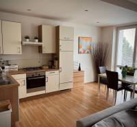 Slnečný 2i byt s balkónmi pri NC Nivy - Kuchyňa v 2-izbovom byte s jedálenským stolom a podlahou s dreveným dekorom.