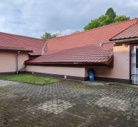 Predaj Domu (obchodného priestoru) v obci Lovča - Rodinný dom v Lovči s dlaždeným dvorom a červenou strechou.