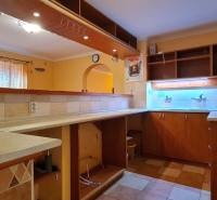 Predaj Domu (obchodného priestoru) v obci Lovča - Kuchyňa v rodinnom dome s drevenými skrinkami, osvetlením a dlažbou.