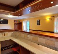 Predaj Domu v obci Lovča - Interiér rodinného domu s barom, dreveným nábytkom a televíziou, svetlý priestor.