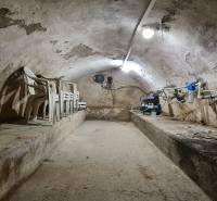 Predaj Domu v obci Lovča - Klenutý kamenný suterén so stoličkami a rozvodmi, typický interiér rodinného domu.