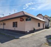 Predaj Domu v obci Lovča - Rodinný dom v Lovči s parkovaním a drevenými obkladmi, vedľa súkromného auta.