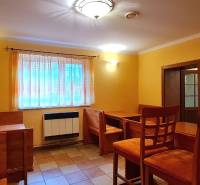 Predaj Domu (obchodného priestoru) v obci Lovča - Jasne osvetlený interiér rodinného domu s dreveným nábytkom a oranžovými stenami.