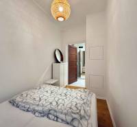 2-izbový byt 45m2 | Sklenárová - Ružinov - Spálňa s posteľou a podlahou s dreveným dekorom v 2-izbovom byte.