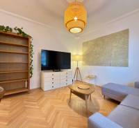 2-izbový byt 45m2 | Sklenárová - Ružinov - Obývacia izba v 2-izbovom byte s podlahou s dreveným dekorom a pohodlnou pohovkou.