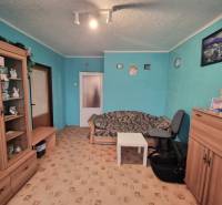 Predaj 3 - izbového bytu v Kuklove !!! - Izba v 3-izbovom byte s tyrkysovými stenami, hnedým nábytkom a vzorovaným kobercom.