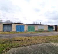 Predaj 3 - izbového bytu v Kuklove !!! - Budova so sériou pestrých garážových brán v Kuklove, vedľa asfaltovej cesty.