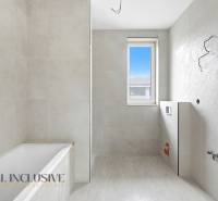 Na predaj 4-izbové novostavby, Veľká Paka - Kúpeľňa v rodinnom dome s vaňou, oknom a svetlými obkladmi.