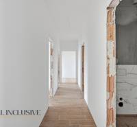 Na predaj 4-izbové novostavby, Veľká Paka - Chodba v rodinnom dome s bielymi stenami a podlahou s dreveným dekorom.