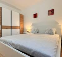 Prenájom 2 izbový byt Trenčín s vlastným parkovaním a terasou - Spálňa v 2-izbovom byte s veľkou posteľou, šatníkovou skriňou a podlahou s dreveným dekorom.