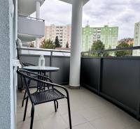 Prenájom 2 izbový byt Trenčín s vlastným parkovaním a terasou - Balkón 2-izbového bytu na Halalovke v Trenčíne so stolom a stoličkami, výhľad na paneláky.