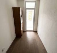 Ponuka na prenájom 2,5 izbový byt Zl. Potok - Úzky interiér 2-izbového bytu s podlahou s dreveným dekorom a skrinkou.