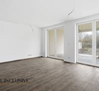 Na predaj 4-izbové novostavby, Veľká Paka - Priestranná izba v rodinnom dome s veľkými oknami a podlahou s dreveným dekorom.