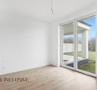 Na predaj 4-izbové novostavby, Veľká Paka - Izba v rodinnom dome s veľkým oknom a podlahou s dreveným dekorom.