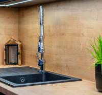 PRENÁJOM | 3i byt v centre Prešova | ZARIADENÝ - Kuchynský kút v 3-izbovom byte s čiernym drezom, dekorom dreva a rastlinou.