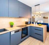 PRENÁJOM | 3i byt v centre Prešova | ZARIADENÝ - Kuchyňa v 3-izbovom byte s podlahou s dreveným dekorom a modrými skrinkami.