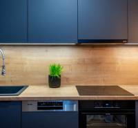 PRENÁJOM | 3i byt v centre Prešova | ZARIADENÝ - Kuchynská linka s tmavými úložnými skrinkami a podlahou s dreveným dekorom.