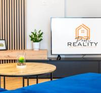 PRENÁJOM | 3i byt v centre Prešova | ZARIADENÝ - Obývacia izba s TV stolíkom, konferenčným stolíkom a podlahou s dreveným dekorom v 3-izbovom byte.