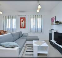 PRIVLAKA - BYT S4- dvojizbový byt 63,42 m2 vzdialený 150 m od mora - Obývačka v 2-izbovom byte s pohodlným gaučom, bielym nábytkom a televízorom.