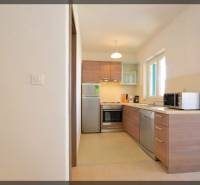 PRIVLAKA - BYT S4- dvojizbový byt 63,42 m2 vzdialený 150 m od mora - Kuchyňa v 2-izbovom byte s dreveným dekorom a spotrebičmi, svetlé farby.