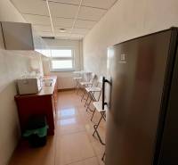 Prenájom kancelárskych priestorov 355 m2 ul. Stará Vajnorská - Úzka kuchynka s linoleom na zemi, chladničkou a oknom v kanceláriách.