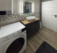 Moderný 3-izbový byt so záhradou Šamorín-Kráľovianky - Kúpeľňa s práčkou a umývadlom v 3-izbovom byte, malá mozaika na stene.