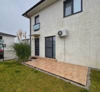 Moderný 3-izbový byt so záhradou Šamorín-Kráľovianky - 3-izbový byt na Kráľoviankach má terasu a trávnatú plochu so šedou fasádou.