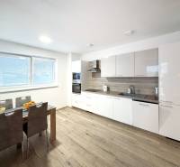 Moderný 3-izbový byt so záhradou Šamorín-Kráľovianky - Kuchyňa v 3-izbovom byte s modernou linkou a podlahou s dreveným dekorom.