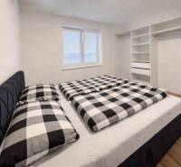 Moderný 3-izbový byt so záhradou Šamorín-Kráľovianky - Spálňa v 3-izbovom byte so vstavanou skriňou a podlahou s dreveným dekorom.