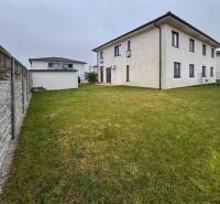 Moderný 3-izbový byt so záhradou Šamorín-Kráľovianky - Exteriér 3-izbového bytu na ulici Kráľovianky v Kráľoviankach s trávnikom a plotom.