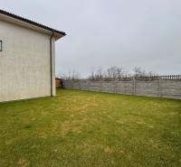 Moderný 3-izbový byt so záhradou Šamorín-Kráľovianky - Záhrada pri dome s trávnatou plochou a oplotením v Kráľoviankach.