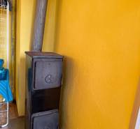 Na predaj  záhradná chata Zelený Dvor Košice - Žltá stena s liatinovými kachľami v chate.