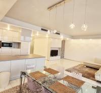 Luxusný 3-izb. byt s famóznym výhľadom na Dunaj, River Park - Priestranný obývací priestor v 3-izbovom byte s kuchyňou, jedálenským stolom a pohodlnou sedačkou.