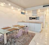 Luxusný 3-izb. byt s famóznym výhľadom na Dunaj, River Park - Kuchyňa v 3-izbovom byte s jedálenským stolom a bielou dlažbou.