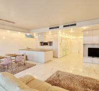 Luxusný 3-izb. byt s famóznym výhľadom na Dunaj, River Park - Obývacia izba s kuchynským ostrovom, jedálenským stolom a TV v 3-izbovom byte.