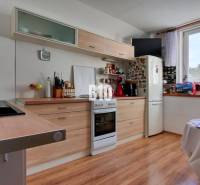 Praktický 8-izbový rodinný dom na Bystričke: Vhodný pre veľkú rodinu z - Kuchyňa v rodinnom dome s dreveným dekorom a výhľadom z okna.